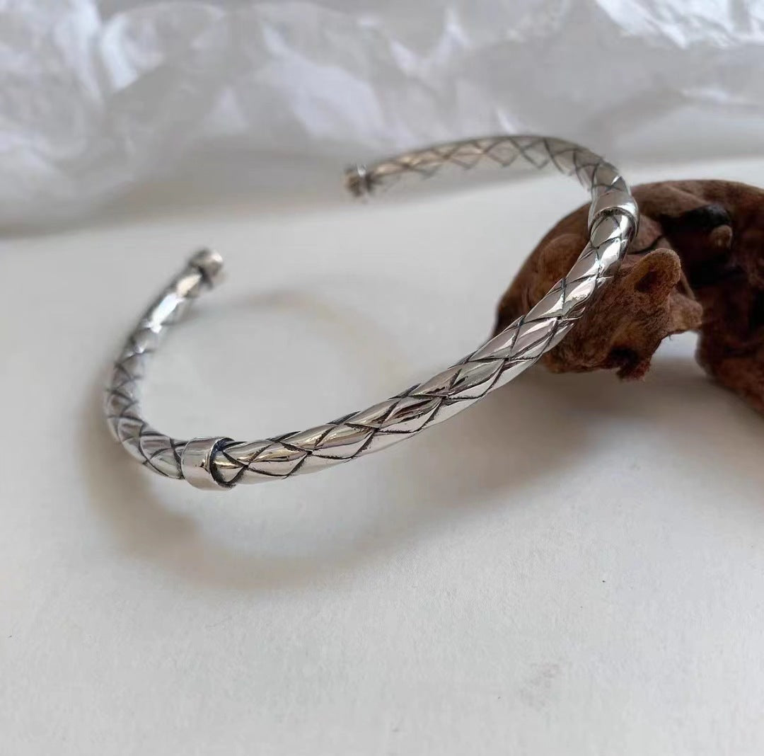 Luxury Metal Bracelet with intricate braided design in polished silver-tone finish on a neutral background
